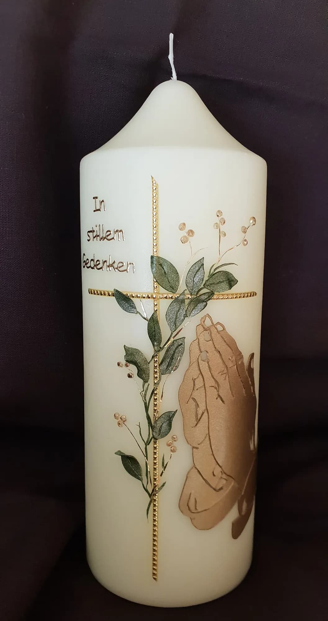 Gedenkkerze mit goldenem Kreuz und betenden Händen