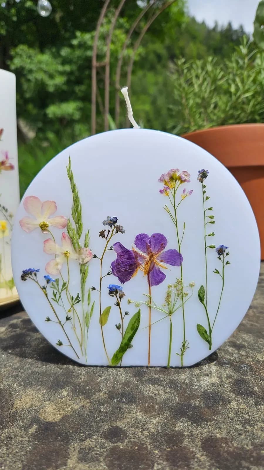 Runde Kerze mit gepressten Wiesenblumen und Gräsern