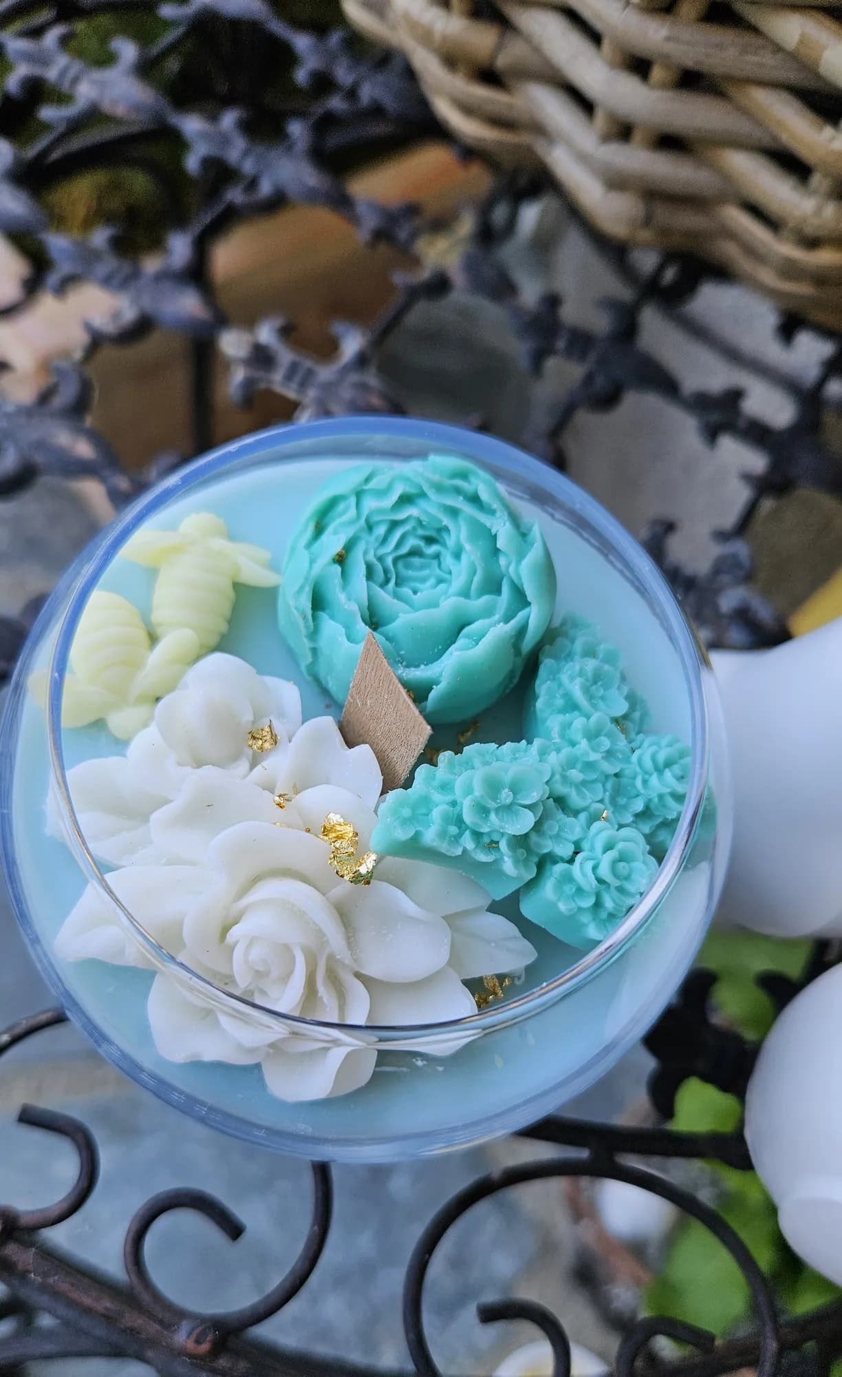 Rundes Glas mit mintgrünen und weißen Blütenkerzen und zarten Goldakzenten