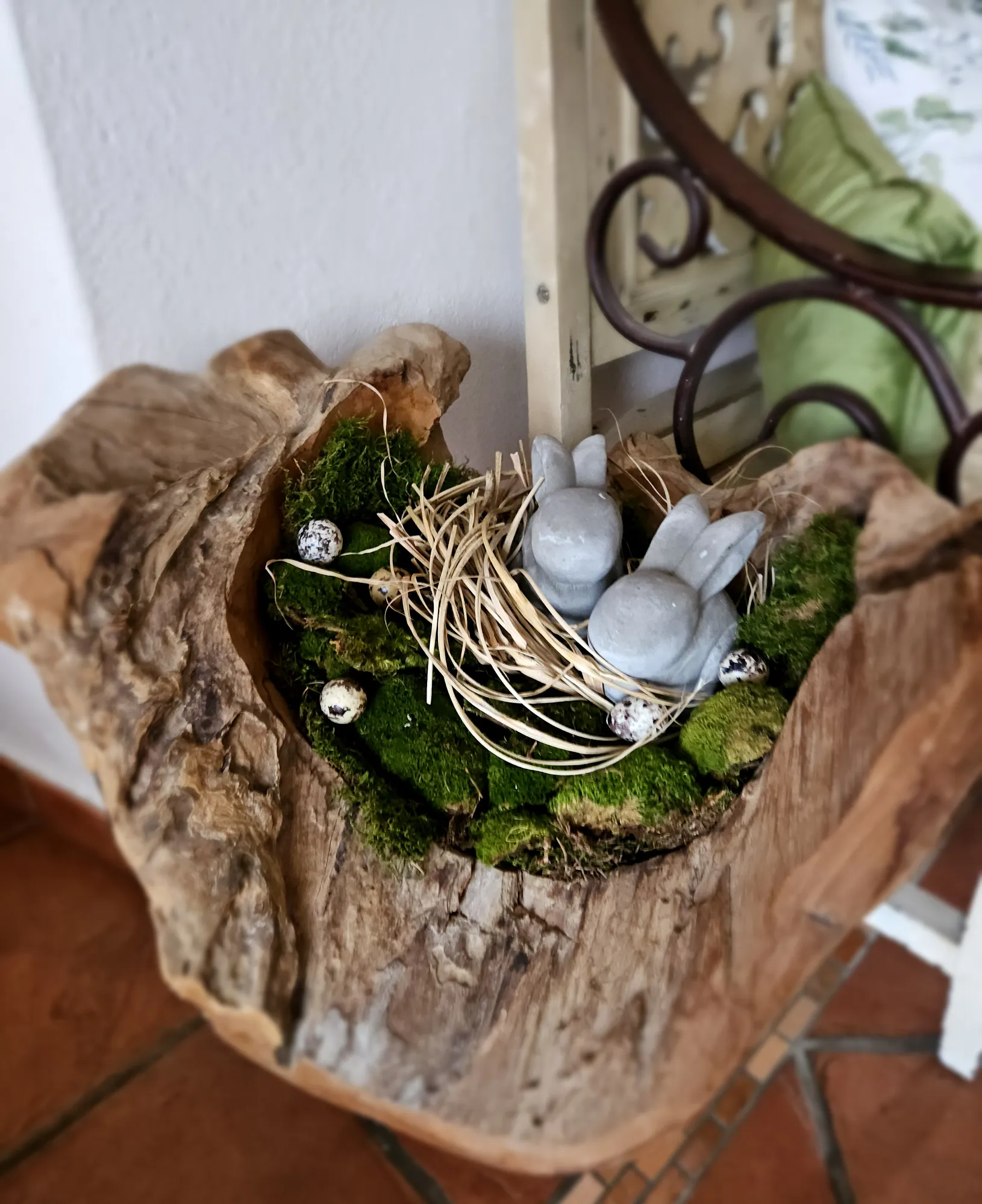 Frühlingsdeko mit Moos und Keramikhasen in einer Schale aus Wurzelholz
