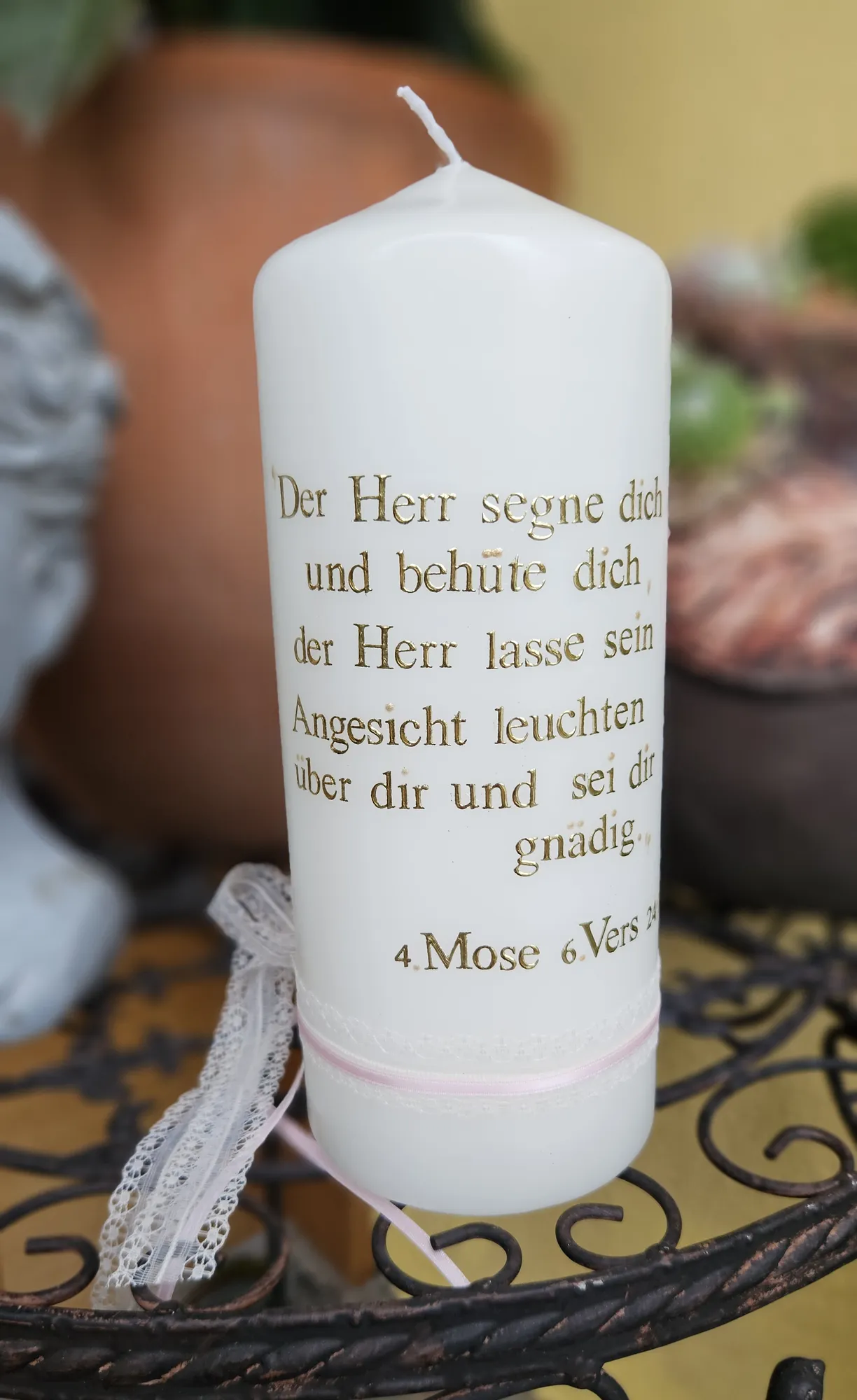 Weiße Taufkerze mit goldenem Segensspruch und zartem Blütenzweig