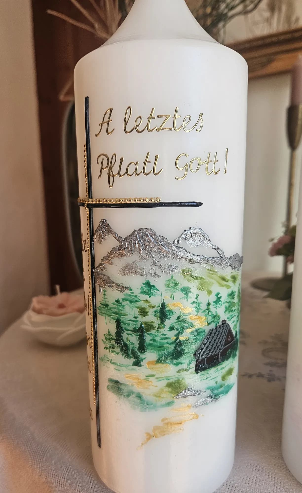 Weiße Trauerkerze mit gemalter Berglandschaft, Wald und Almhütte